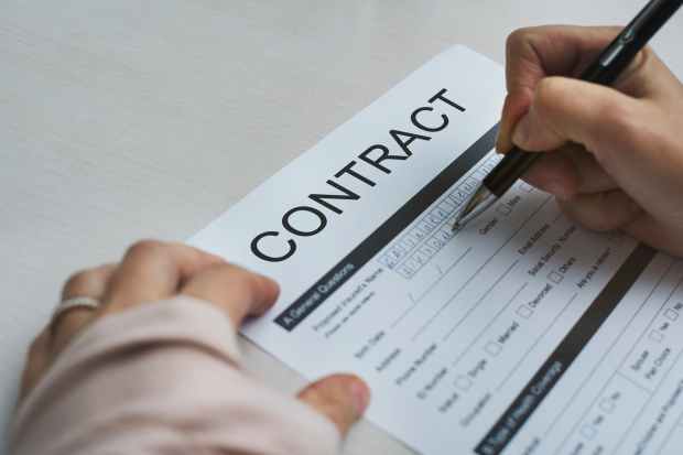 person signing contract paper